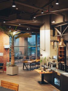 intérieur d'un loft très haut de plafonds, avec des murs en brique, de large fenêtre et des pourtres apparentes