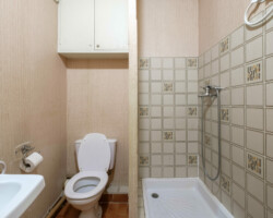 Ancienne salle de douche avec papier peint mural Salle de douche ancienne dans un studio avec équipements d’origine.