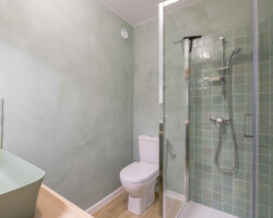 Douche moderne avec porte pivotante Douche moderne installée lors de la réhabilitation du studio.